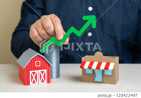 Man holds green growth arrow over farm and store. Increase in profits from the sale and marketing of farm products. Growth in agri-business, local product sales, and market integration. Man holds green growth arrow over farm and store. Increase in profits from the sale and marketing of farm products. Growth in agri-business, local product sales, and market integration. 128422497