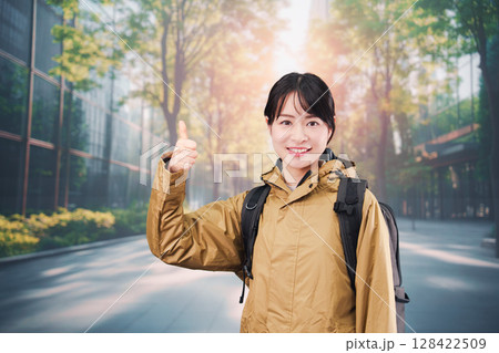 レインコートを着て通勤をする若い女性会社員 128422509