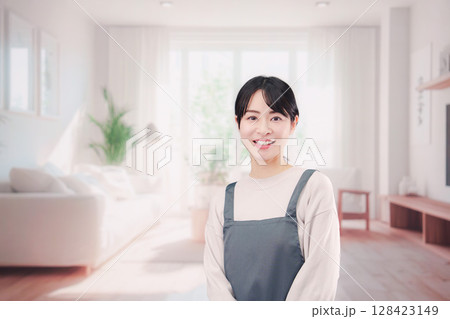 エプロンをしてお客様の家で働く家事代行の女性 128423149