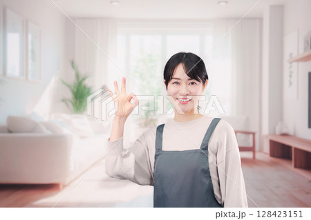 エプロンをしてお客様の家で働く家事代行の女性 128423151