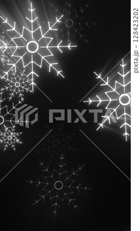 Bright glowing snowflakes on a dark black background with radial light streaks and winter ambiance Bright glowing snowflakes on a dark black background with radial light streaks and winter ambiance 128423202