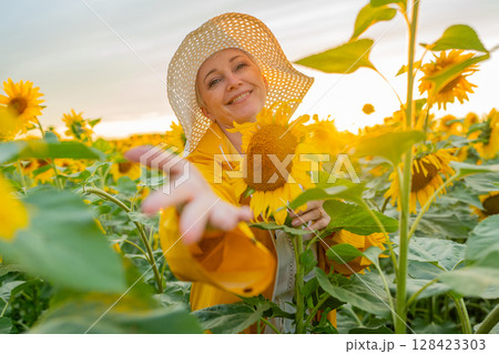 A Joyful Happy Senior Woman in a Field of Sunflowers is Celebrating the Natural Beauty Around Her A Joyful Happy Senior Woman in a Field of Sunflowers is Celebrating the Natural Beauty Around Her 128423303