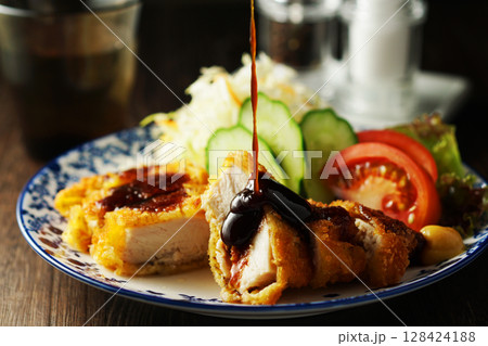 チキンカツに特製ソースをかける チキンカツに特製ソースをかける 128424188