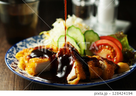 チキンカツに特製ソースをかける チキンカツに特製ソースをかける 128424194