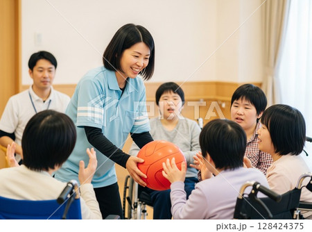 障がい者と支援員の笑顔のレクリエーション障がい者,障害者, ,運動,スポーツ,ゲーム,紙飛行機 128424375