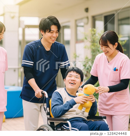 車いすを押している様子　障がい者と笑顔で交流する男女の支援員  利用者さんの笑顔 128424448