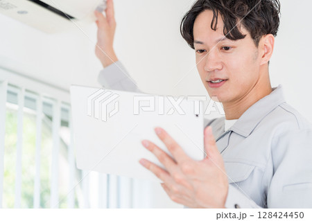 エアコンの動作確認をする作業員の男性。 128424450