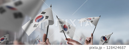 South Korean flags in their hands on a blurred urban background 128424687