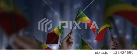 Congo flags in their hands on a blurred urban background 128424696