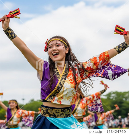 よさこい祭りで鳴子を持って笑顔で踊る美しい女性  128424760