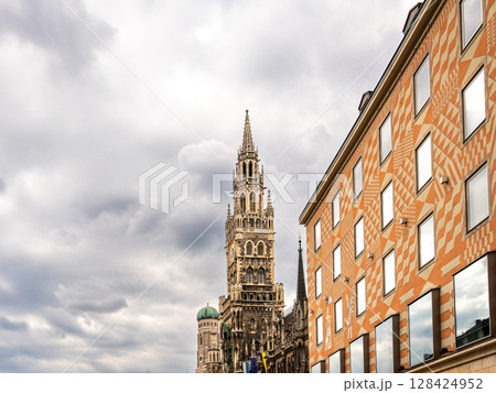 Iconic New Town Hall Tower In Munich With Ornate Gothic Architecture: Majestic Landmark Rising Behind Colorful Facade Near Marienplatz In The Historic City Center Of The Bavarian Capital Iconic New Town Hall Tower In Munich With Ornate Gothic Architecture: Majestic Landmark Rising Behind Colorful Facade Near Marienplatz In The Historic City Center Of The Bavarian Capital 128424952