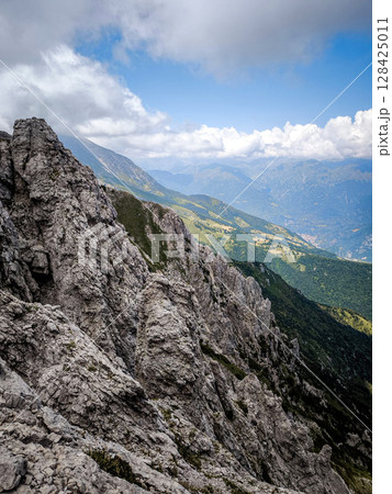 Rugged Alpine Peaks And Verdant Valleys In The Grigna Massif: Scenic Mountain Landscape In Lombardy Region Of Northern Italy Near Lake Como Rugged Alpine Peaks And Verdant Valleys In The Grigna Massif: Scenic Mountain Landscape In Lombardy Region Of Northern Italy Near Lake Como 128425011