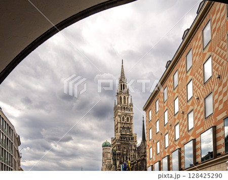 Iconic New Town Hall Tower In Munich With Ornate Gothic Architecture: Majestic Landmark Rising Behind Colorful Facade Near Marienplatz In The Historic City Center Of The Bavarian Capital Iconic New Town Hall Tower In Munich With Ornate Gothic Architecture: Majestic Landmark Rising Behind Colorful Facade Near Marienplatz In The Historic City Center Of The Bavarian Capital 128425290