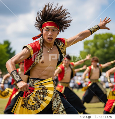 よさこい祭りで龍の絵の金の扇子を持って力強く若い踊る男性の踊り子 ほとばしる汗  髪を振り乱して踊る 128425320