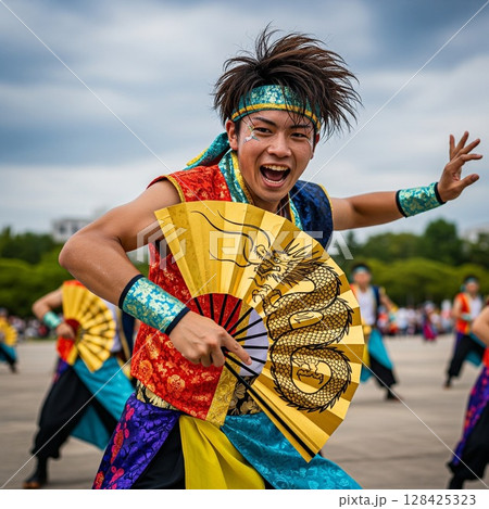 よさこい祭りで龍の絵の金の扇子を持って力強く若い踊る男性の踊り子 ほとばしる汗 髪を振り乱して踊る よさこい祭りで龍の絵の金の扇子を持って力強く若い踊る男性の踊り子 ほとばしる汗 髪を振り乱して踊る 128425323