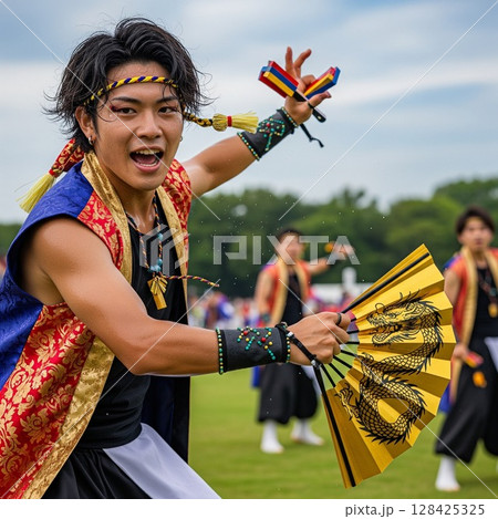 よさこい祭りで龍の絵の金の扇子を持って力強く若い踊る男性の踊り子 ほとばしる汗 髪を振り乱して踊る よさこい祭りで龍の絵の金の扇子を持って力強く若い踊る男性の踊り子 ほとばしる汗 髪を振り乱して踊る 128425325
