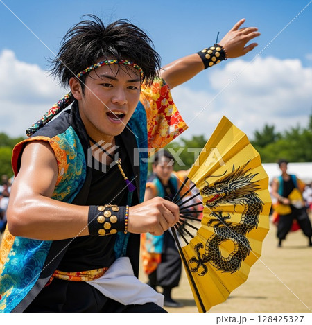 よさこい祭りで龍の絵の金の扇子を持って力強く若い踊る男性の踊り子 ほとばしる汗  髪を振り乱して踊る 128425327