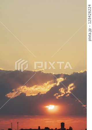 Beautiful sunset in the city with clouds and sun rays. The sun sets over the city. Beautiful sunset in the city with clouds and sun rays. The sun sets over the city. 128426224