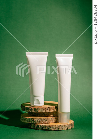 Two skincare tubes against a green backdrop 128426834