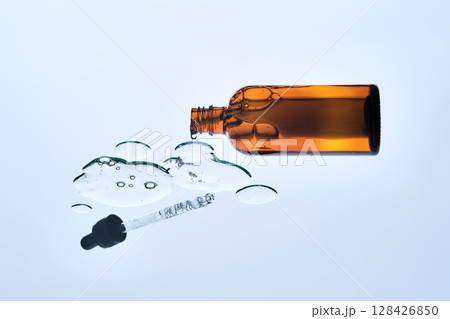 The texture of the serum and the glass bottle. View from below. The texture of the serum and the glass bottle. View from below. 128426850