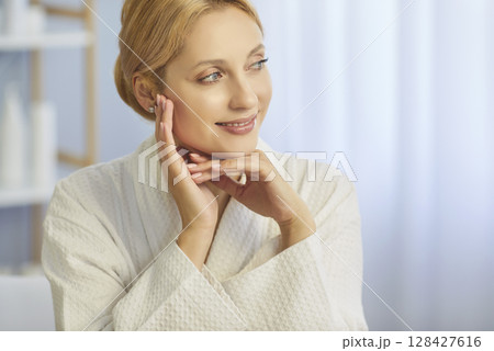 Portrait of young woman with natural make up sitting in spa salon and smiling. Skin care concept. 128427616