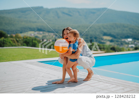 Little child and mother enjoying outdoor playtime with inflatable ball Little child and mother enjoying outdoor playtime with inflatable ball 128428212