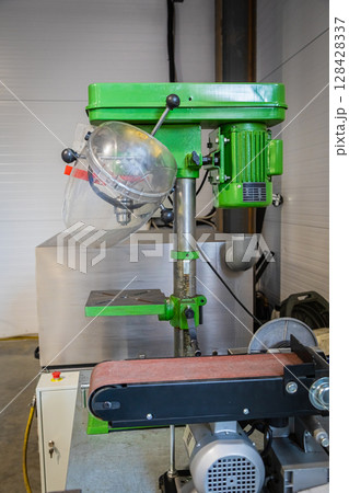 Green bench drill press and belt sander in workshop Green bench drill press and belt sander in workshop 128428337