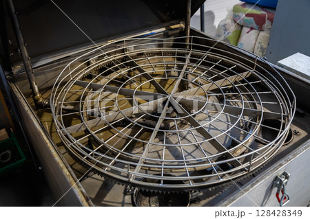 Industrial parts washer cleaning metal components with rotating basket Industrial parts washer cleaning metal components with rotating basket 128428349