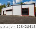 Modern warehouse building exterior with parking lot on a sunny day 128428418