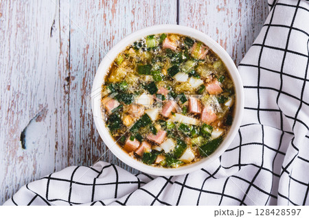 Close up of traditional cold vegetable soup with kvass in a bowl on the table top view 128428597