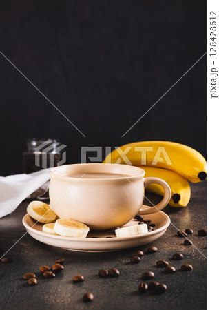 Alternative cold banana coffee in a cup on the table vertical view Alternative cold banana coffee in a cup on the table vertical view 128428612