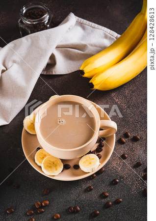 Blended frozen banana coffee in a cup on the table vertical view Blended frozen banana coffee in a cup on the table vertical view 128428613