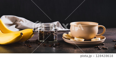 Blended frozen banana coffee in a cup on the table web banner 128428618