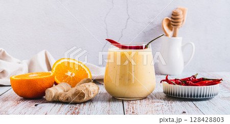 Smoothie with orange, ginger and cayenne pepper in a glass on the table web banner Smoothie with orange, ginger and cayenne pepper in a glass on the table web banner 128428803