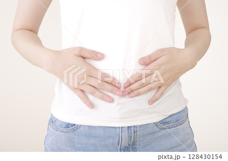 下腹部に手を当てる女性 下腹部に手を当てる女性 128430154