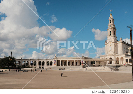 Wide view of Basilica of Our Lady of the Rosary and colonnade at Sanctuary of Fatima Portugal with blue sky and clouds iconic Catholic pilgrimage site and architectural landmark. High quality photo 128430280