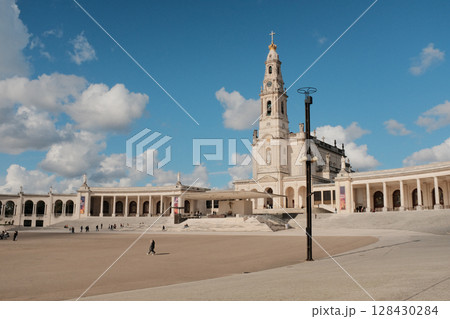 Wide view of Basilica of Our Lady of the Rosary and colonnade at Sanctuary of Fatima Portugal with blue sky and clouds iconic Catholic pilgrimage site and architectural landmark. High quality photo Wide view of Basilica of Our Lady of the Rosary and colonnade at Sanctuary of Fatima Portugal with blue sky and clouds iconic Catholic pilgrimage site and architectural landmark. High quality photo 128430284