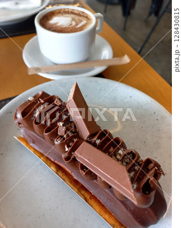 Gourmet chocolate dessert with layered decoration and cup of cappuccino Gourmet chocolate dessert with layered decoration and cup of cappuccino 128430815