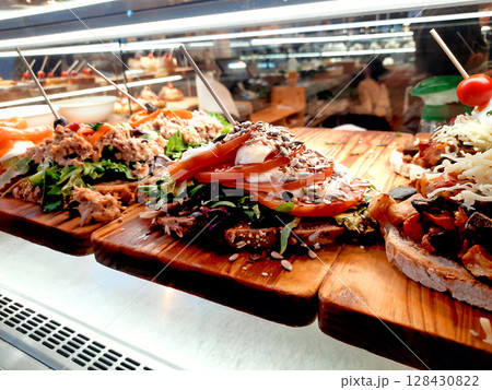 Colorful Open Sandwiches with Fresh Toppings Displayed in Restaurant Showcase 128430822