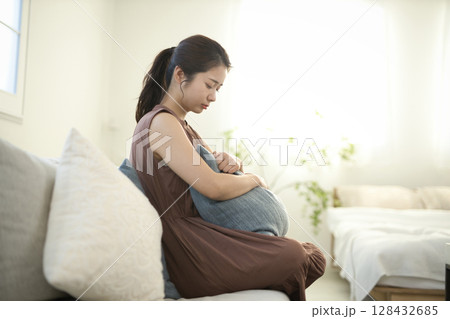 ソファに座る体調不良の20代女性 ソファに座る体調不良の20代女性 128432685