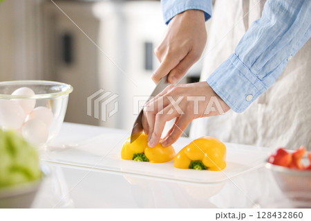 野菜を切る若い男性の手元 128432860