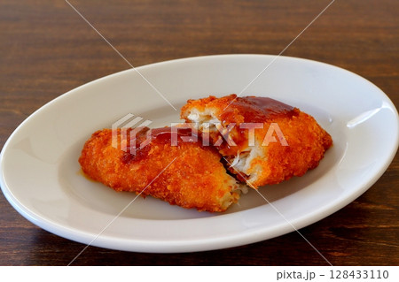 ウスターソースをかけた白身魚のフライ 128433110