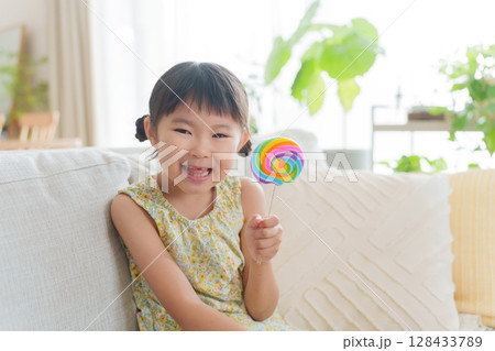 お菓子の飴を食べる子供 お菓子の飴を食べる子供 128433789