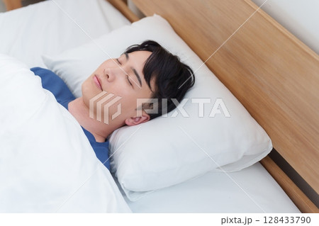 朝ベッドで寝る男性 128433790