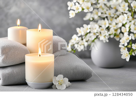 Soft candles illuminate serene space with cozy blankets and delicate flowers, creating peaceful atmosphere perfect for relaxation and meditation Soft candles illuminate serene space with cozy blankets and delicate flowers, creating peaceful atmosphere perfect for relaxation and meditation 128434050