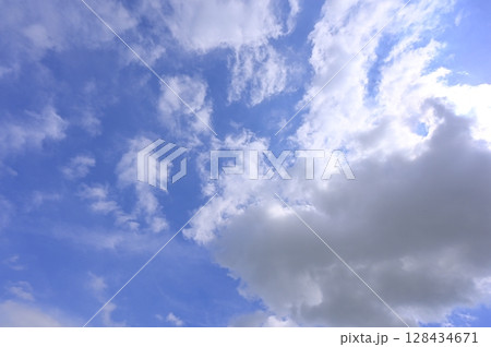 でかい雲から太陽光が漏れ出している青空 128434671