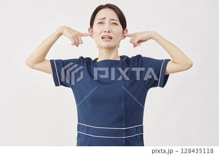 女性　美容看護師　耳を塞ぐ　白背景 128435118
