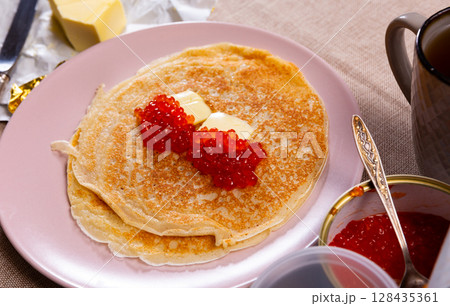Pancakes served with red caviar and butter Pancakes served with red caviar and butter 128435361