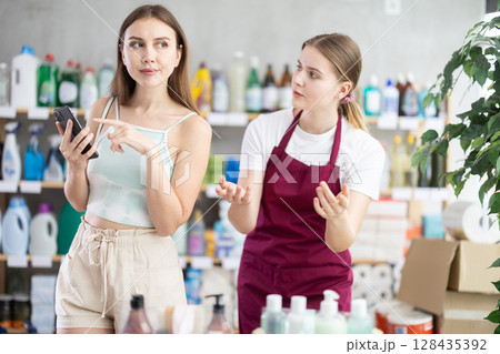 saleswoman shows a woman the range of products in a household store saleswoman shows a woman the range of products in a household store 128435392