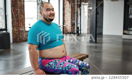 ジムのベンチに座って微笑む日本人男性フィットネスインストラクター 128435507